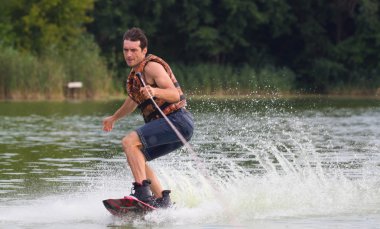 Yeşil parkta gölet erkek wakeboarder.