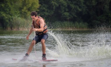 Yeşil parkta gölet erkek wakeboarder.