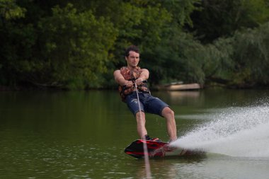 Yeşil parkta gölet erkek wakeboarder.