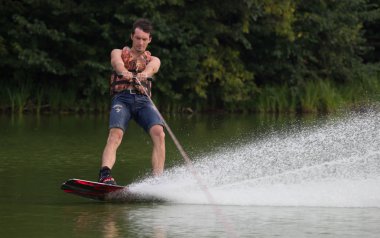 Yeşil parkta gölet erkek wakeboarder.