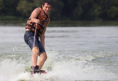 Yeşil parkta gölet erkek wakeboarder.