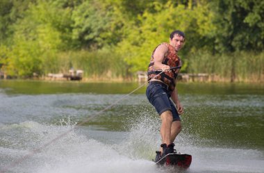 Yeşil parkta gölet erkek wakeboarder.
