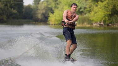 Yeşil parkta gölet erkek wakeboarder.