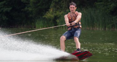 Yeşil parkta gölet erkek wakeboarder.