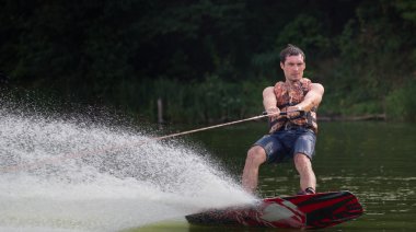 Yeşil parkta gölet erkek wakeboarder.