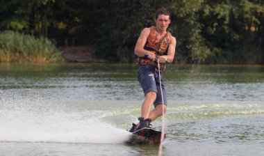 Yeşil parkta gölet erkek wakeboarder.