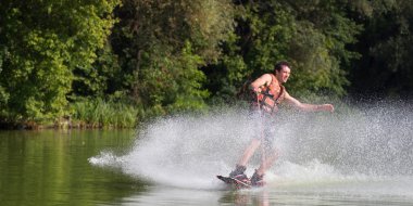 Yeşil parkta gölet erkek wakeboarder.