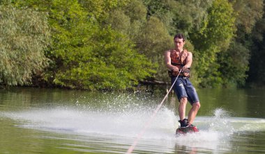 Yeşil parkta gölet erkek wakeboarder.