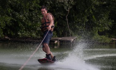 Yeşil parkta gölet erkek wakeboarder.