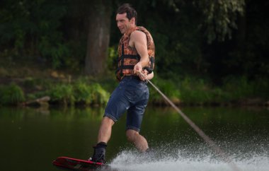 Yeşil parkta gölet erkek wakeboarder.