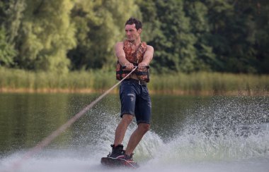 Yeşil parkta gölet erkek wakeboarder.