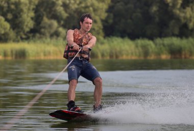 Yeşil parkta gölet erkek wakeboarder.