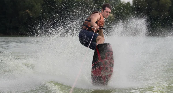 Yeşil parkta gölet erkek wakeboarder.