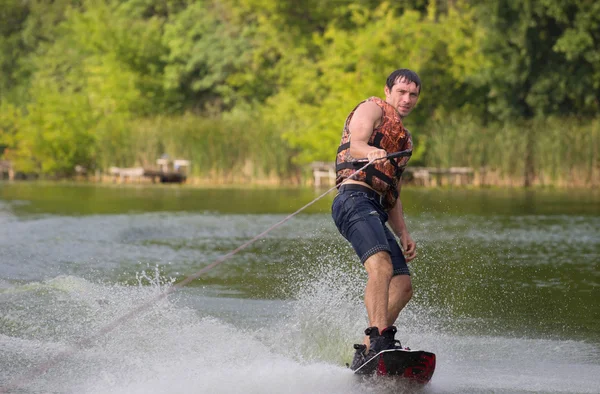 Yeşil parkta gölet erkek wakeboarder.