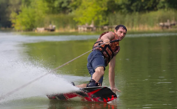 Yeşil parkta gölet erkek wakeboarder.