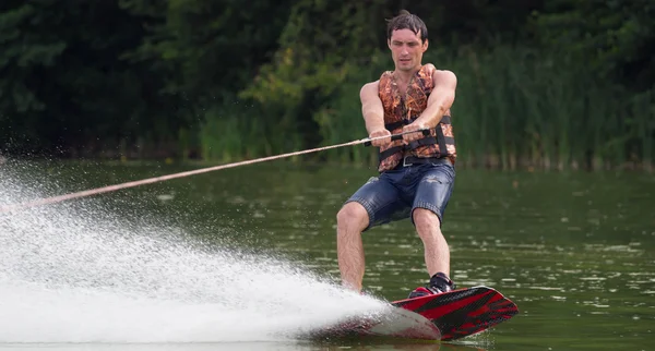 Yeşil parkta gölet erkek wakeboarder.