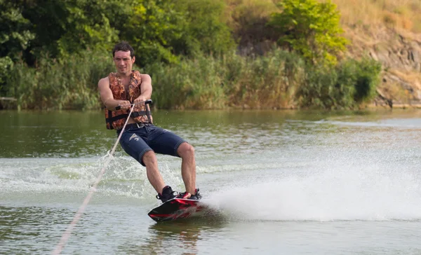 Yeşil parkta gölet erkek wakeboarder.