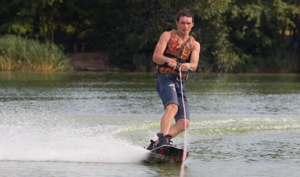 Yeşil parkta gölet erkek wakeboarder.