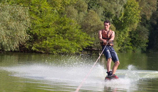 Yeşil parkta gölet erkek wakeboarder.