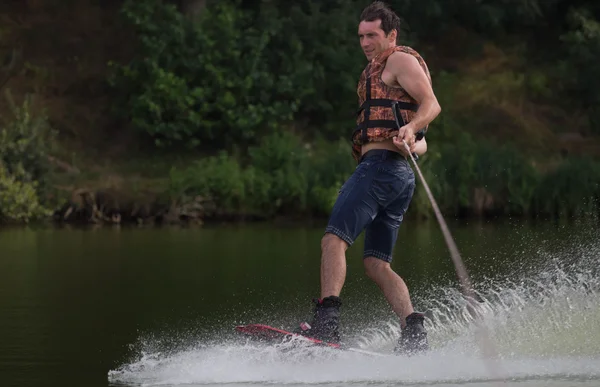 Yeşil parkta gölet erkek wakeboarder.