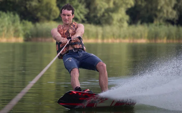 Yeşil parkta gölet erkek wakeboarder.