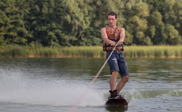 Yeşil parkta gölet erkek wakeboarder.
