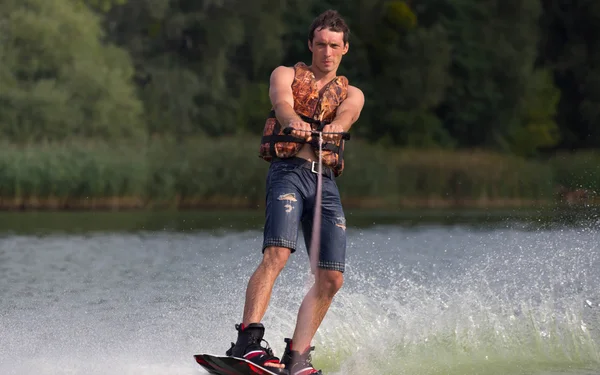Yeşil parkta gölet erkek wakeboarder.