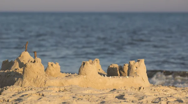 Kumlu kumsalın mavi denizinin güney kıyısında kuleleri olan bir kumdan kale inşa ettim. — Stok fotoğraf