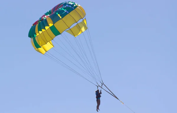 Parachutisme dans un ciel bleu près de la plage de la mer . — Photo