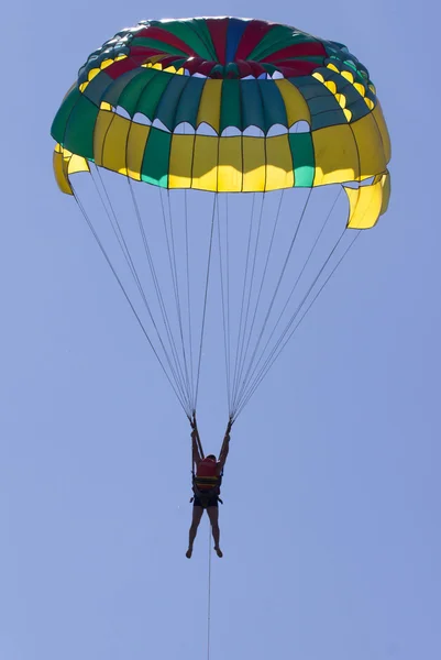 Parasailing v modré obloze blízko pláže. — Stock fotografie