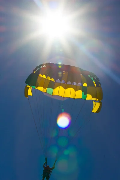 Parachutisme dans un ciel bleu près de la plage de la mer . — Photo