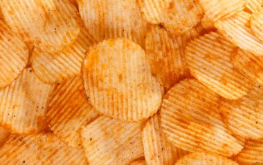 Patates cipslerini ahşap arka planda kapat.