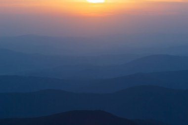 Gün batımında dağların ve sislerin katmanı
