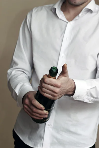 Um garçom de camisa branca abre uma garrafa de champanhe — Fotografia de Stock