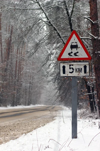 冬季开车。雪冰覆盖警告标志与挡风玻璃上. — 图库照片