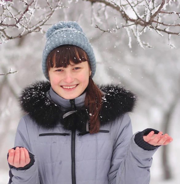 Gelukkig jonge vrouw speelt met een sneeuw buiten. Rechtenvrije Stockafbeeldingen