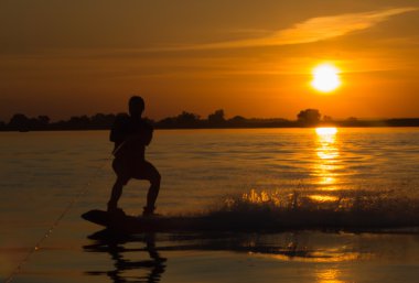 Wakeboarder günbatımı üzerinde hileler yapmak