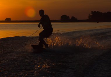 Wakeboarder günbatımı üzerinde hileler yapmak
