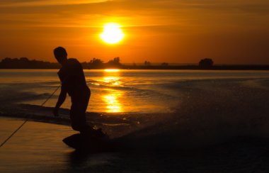 Wakeboarder günbatımı üzerinde hileler yapmak