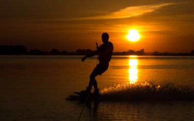 Wakeboarder günbatımı üzerinde hileler yapmak