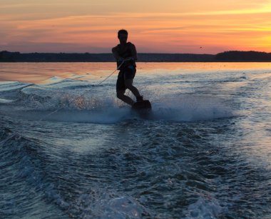 Wakeboarder günbatımı üzerinde hileler yapmak