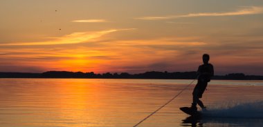 Wakeboarder günbatımı üzerinde hileler yapmak