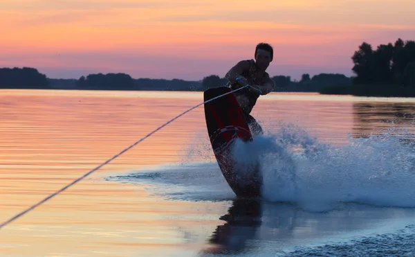 Wakeboarder maken trucs op zonsondergang — Stockfoto