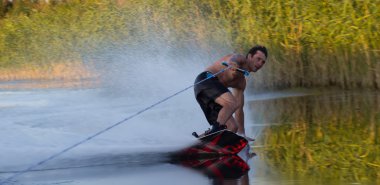 Sprey yanma ile su yoluyla Wakeboarder atlet kayar