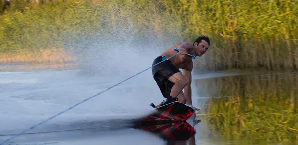 Atleta Wakeboarder scivola attraverso l'acqua con spray bruciante — Foto Stock