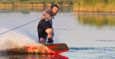 Sprey yanma ile su yoluyla Wakeboarder atlet kayar