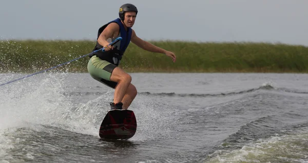 Atleta haciendo trucos en un wakeboard — Foto de Stock