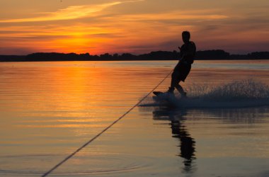 Wakeboarder günbatımı üzerinde hileler yapmak