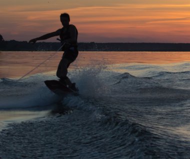 Wakeboarder günbatımı üzerinde hileler yapmak