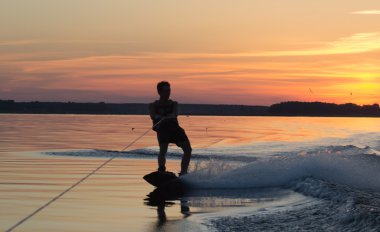 Wakeboarder günbatımı üzerinde hileler yapmak
